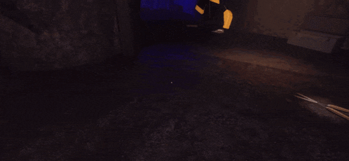 a person is standing in a dark room with a light on the floor