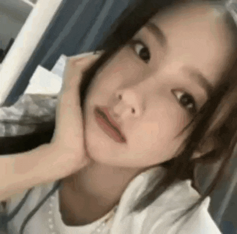 a close up of a woman taking a selfie with her hand on her chin .