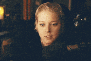 a woman is sitting on a couch holding a glass of wine .