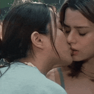 two women are kissing each other on the cheek