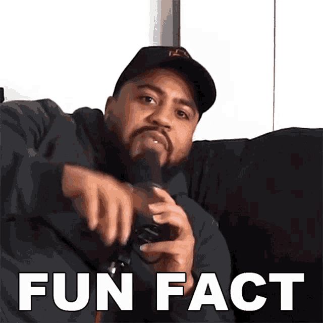 a man sitting on a couch holding a microphone with the words fun fact written below him
