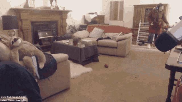a sloth is laying on a couch in a living room with a screen that says daily subs