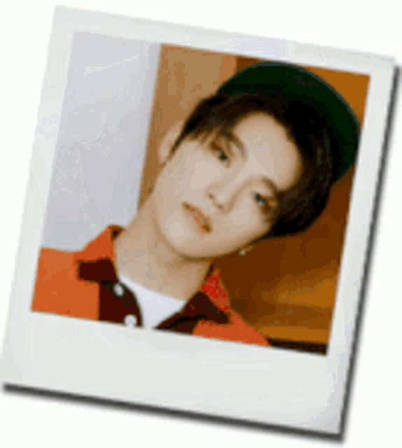 a polaroid of a young man wearing a green hat