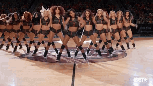 a group of cheerleaders are performing on a basketball court with the bet logo visible in the background