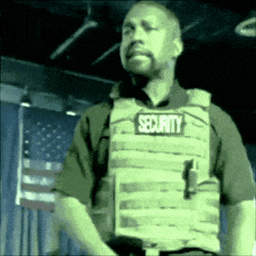 a man wearing a security vest with the word security on it