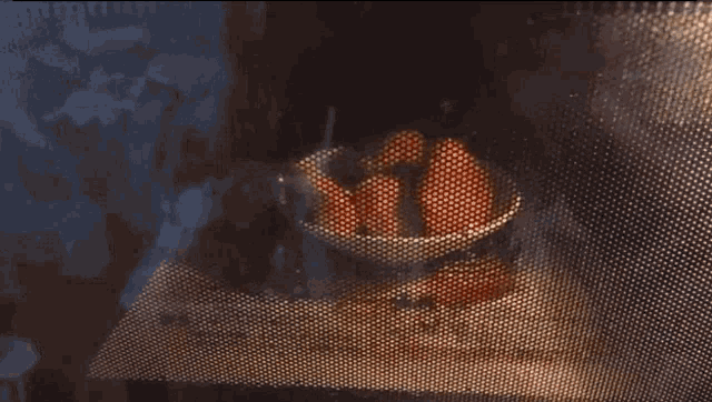 a bowl of food is being cooked in a microwave oven