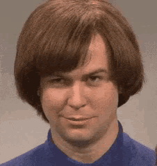a close up of a man 's face with a blue shirt on .