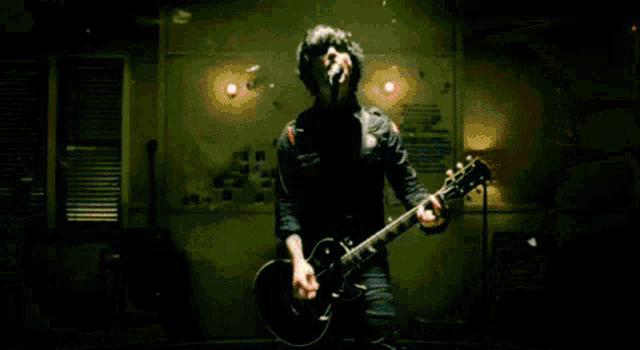 a man is singing into a microphone while playing a guitar in a room .