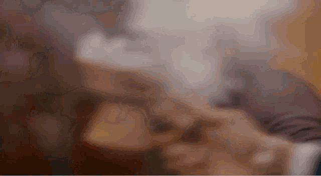 a close up of a person smoking a cigarette with smoke coming out of it .