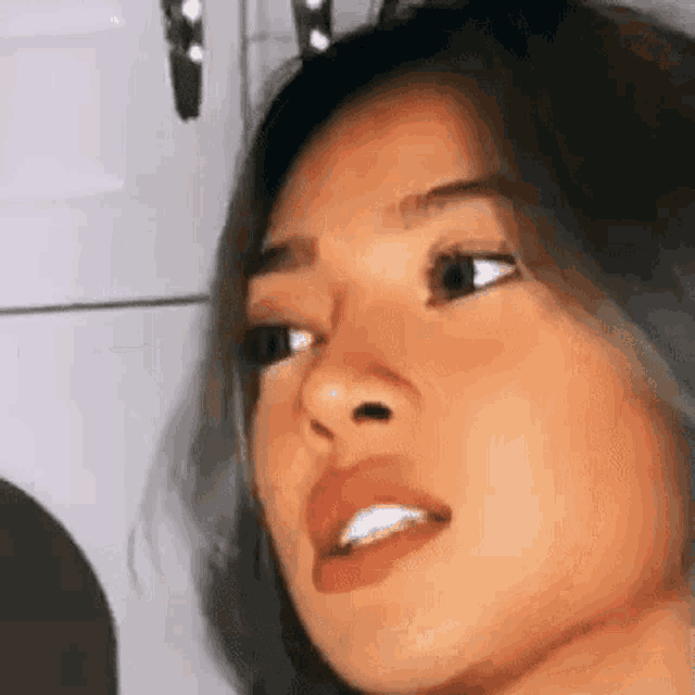 a close up of a woman 's face with her mouth open and a serious look on her face .