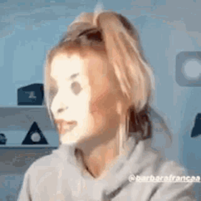 a woman in a ponytail is wearing a mask on her face .