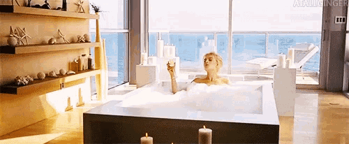 a woman is taking a bath in a bathtub filled with bubbles .