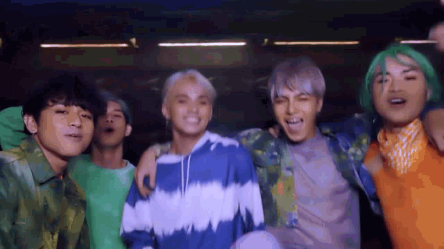 a group of young men with green hair are posing for a picture .