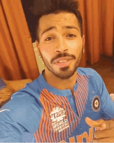 a man with a beard is wearing a blue and orange shirt that says icc world cup twenty20