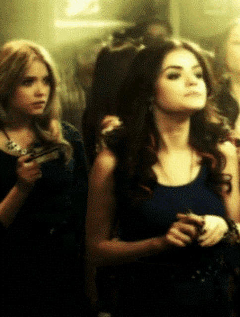 a woman in a blue tank top stands next to another woman