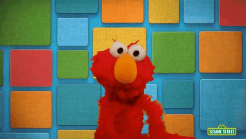 elmo from sesame street is smiling in front of a wall of squares
