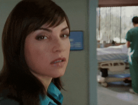 a woman stands in a hallway with a sign that says ' emergency room ' on it