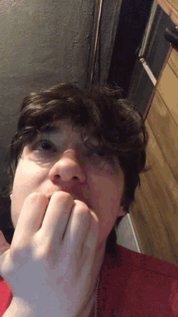 a close up of a man 's face with his hand on his mouth