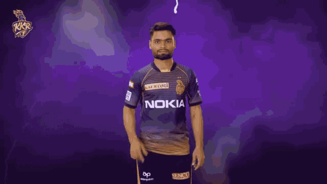 a man in a nokia shirt stands in front of a purple backdrop