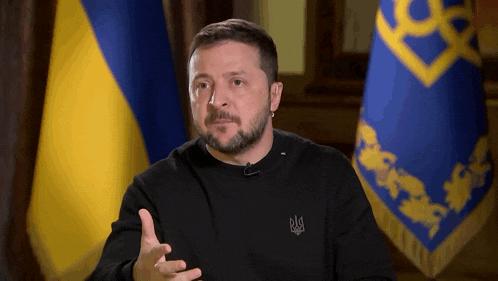 a man with a beard wearing a black shirt with a ukrainian symbol on the front