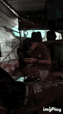 a man is sitting at a table looking at his phone while wearing ear buds