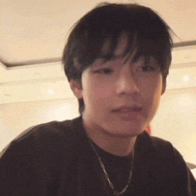 a close up of a young man wearing a black shirt and a chain .