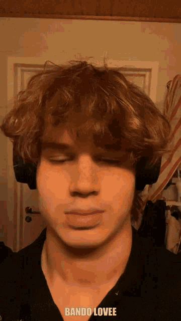 a young man wearing headphones has the word bando lovee written on his face