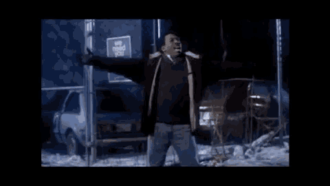 a man with his arms outstretched is standing in front of a truck .