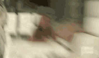 a blurry picture of a person laying on a bed with a bravo logo in the corner .