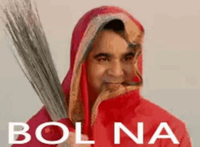 a man in a red hooded jacket is holding a broom in his hand .