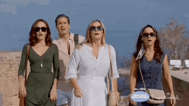 a group of women standing next to each other with a sign that says hallmark
