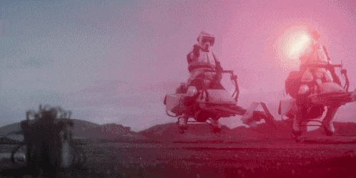 a man is riding a motorcycle in a field with a red light behind him