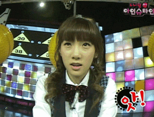 a woman in a bow tie stands in front of a screen that says 30 on it