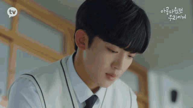 a close up of a young man 's face with a tv logo in the corner