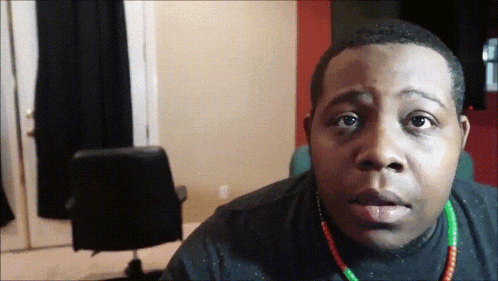 a man wearing a black shirt and a green and red necklace
