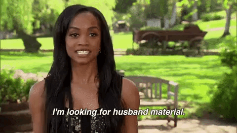 a woman is standing in a park talking about looking for husband material .