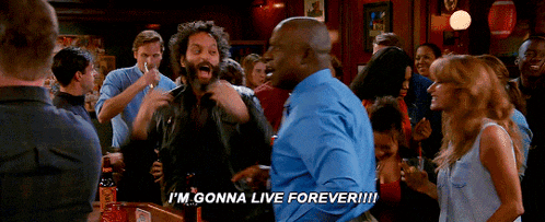 a group of people are dancing in a bar and one man says i 'm gonna live forever !!!