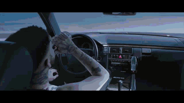 a man in a car with the word amg on the dash