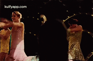 a group of women are dancing on a stage .