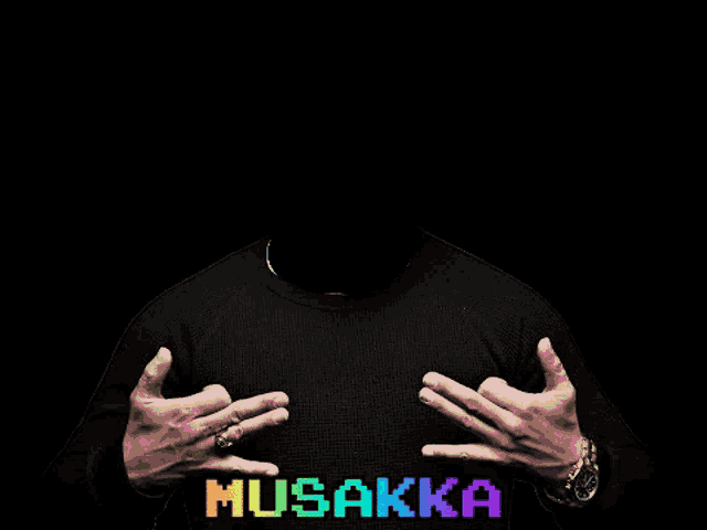 a man is wearing a black sweater with the word musakka on it