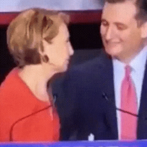 a man in a suit and tie is kissing a woman in a red dress .