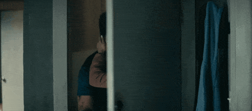 a man and a woman are hugging in a dark room .