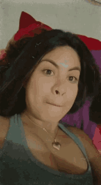 a woman with her eyes closed and a heart necklace