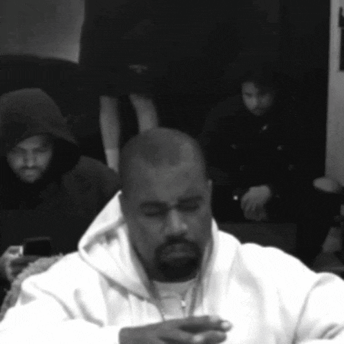 a man in a white hoodie is looking down at something