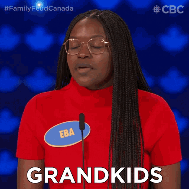 a woman wearing a red shirt with a name tag that says grandkids