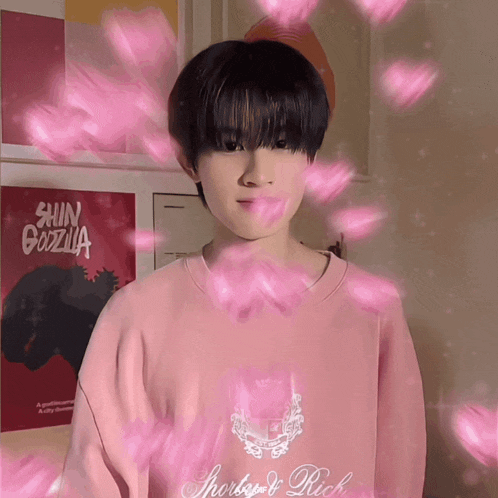 a young man wearing a pink shirt with the word rich on the front