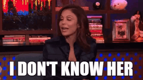 a woman is sitting in front of a bookshelf and says i don 't know her