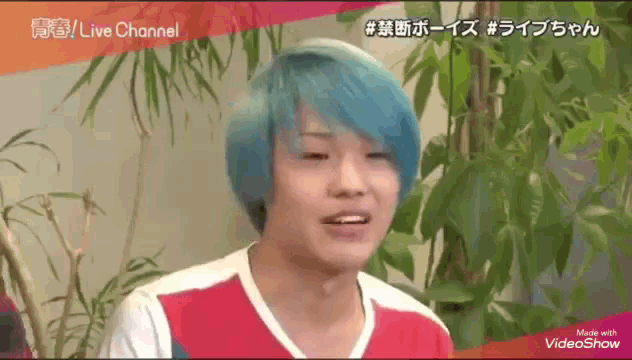a young man with blue hair is wearing a red and white shirt