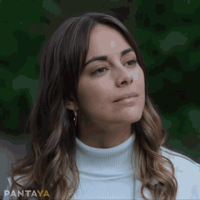 a woman wearing a white turtleneck sweater and hoop earrings with pantaya written on the bottom