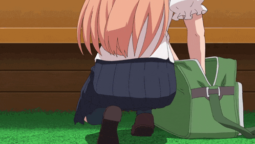 a girl in a school uniform is squatting down next to a green bag